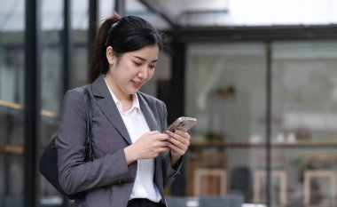 Portrait of a beautiful smiling woman using a mobile phone outdoor
