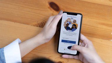 CHIANG MAI, THAILAND - 11 APR 2022: Ev çalışanlarından bir çalışma Microsoft sosyal platformunu indiriyor, evden izole bir şekilde çalışmaya hazır