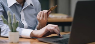 Hands holding credit card, typing on the keyboard of laptop, onine shopping detail close u