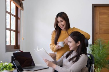 two friends  talking and smiling one to each other  in small break of studying with cup of coffee in hand