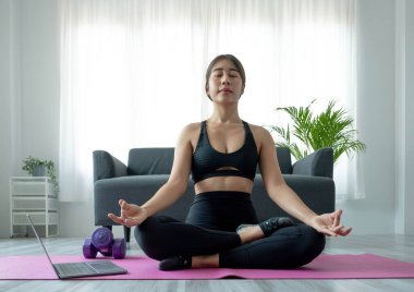 Portrait of young beautiful asian woman stretching warm up exercise workout yoga position at home in living room. Sporty asia girl health care lifestyle.