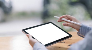 Masanın üzerinde dijital tableti tutan bir kadın resmi ve ekran boş.