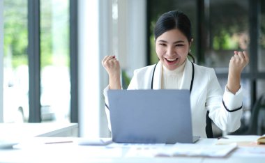 Pretty Asian businesswoman sitting on a laptop And the work came out successfully and the goal was achieved, happy and satisfied with her