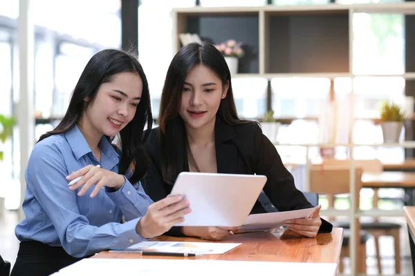 Two businesswoman meeting and working together on tablet in office