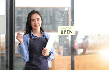 Başlangıçta başarılı olan küçük işletme sahibi, kafeterya restoranında elinde tablet akıllı telefonuyla güzellik kızı standı açmıştı. Kahveci Asyalı kadının portresi. KOBİ girişimci satıcı iş konsepti