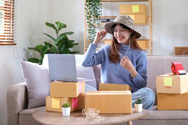Küçük işletme girişimcisi KME, kutuda şapka paketleyen Asyalı kadın. Portre genç Asyalı küçük işletme sahibi ev sahibi, çevrimiçi satış pazarlama teslimatı, KME e-ticaret tele-pazarlama danışmanı
