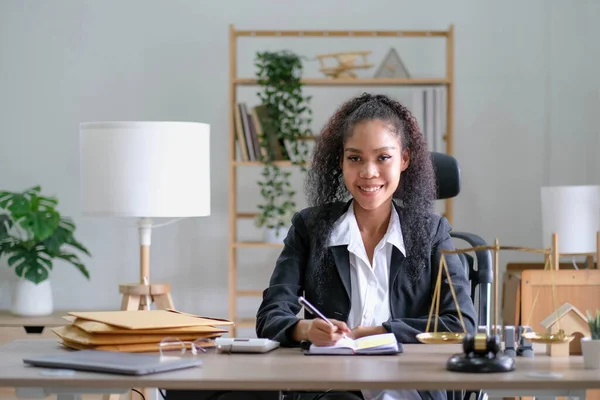 Portrait of young female Lawyer or attorney working in the office, smiling and looking at camera