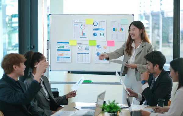 Female Operations Manager Holds Meeting Presentation for a Team of Economists. Asian Woman Uses Digital Whiteboard with Growth Analysis, Charts, Statistics and Data. People Work in Business Office