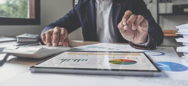 İş adamının dijital tablet kullanma, iş planı yazma, ofis masasında oturması, yer kopyalaması.