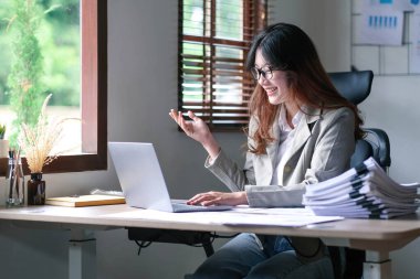 Genç Asyalı iş kadını yeni başlatılan proje sunumu, planlama ve mali istatistikler ve ofisteki yatırım pazarı ile görüştü.