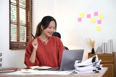 Ofisinde dizüstü bilgisayar ya da defter üzerinde çalışan genç bir kadın. Güzel Freelancer Kadını evinde çalışıyor. Güzel Asyalı iş kadını konsepti