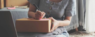 Küçük girişimciler, kahverengi paket kutuları, küçük ev kurma fikirleri olan ürünleri düzenleyerek bir ev kurarlar..