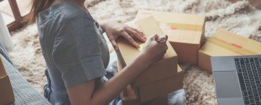 Küçük girişimciler, kahverengi paket kutuları, küçük ev kurma fikirleri olan ürünleri düzenleyerek bir ev kurarlar..