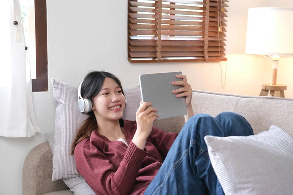 Jovem Sorrindo Atraente Usando Tablet Ouvir Música Sofá Casa Conceito — Fotografia de Stock