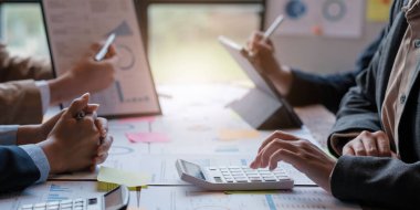 İş veri özeti raporunu, muhasebe belgesini ve ofisteki dizüstü bilgisayarını, iş toplantısı kavramını hesaplamak için hesap makinesiyle çalışan muhasebeci veya muhasebeci.