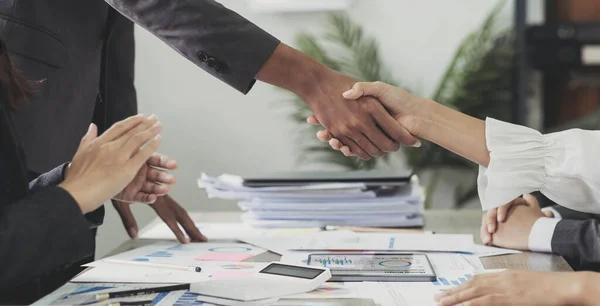 会社員が事務所の会議テーブルで握手をします 若いビジネスマンとビジネスマンの労働者は投資契約の合意を表明する — ストック写真
