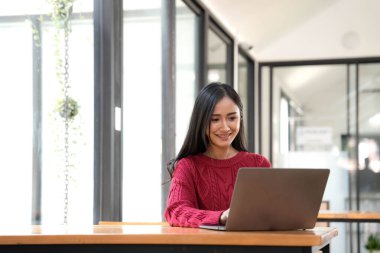 Young asian businesswoman beautiful charming smiling and using laptop computer in office..