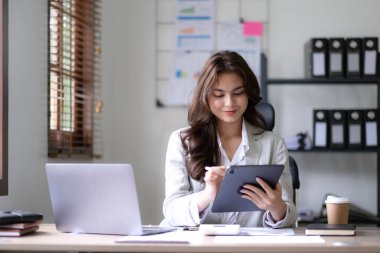 Bir ofis masası, vergi, rapor, muhasebe, istatistik ve analitik araştırma kavramında matematik finansmanı için hesap makinesi ve dizüstü bilgisayar kullanan Asyalı İş kadını.