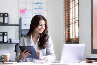 Bir ofis masası, vergi, rapor, muhasebe, istatistik ve analitik araştırma kavramında matematik finansmanı için hesap makinesi ve dizüstü bilgisayar kullanan Asyalı İş kadını.