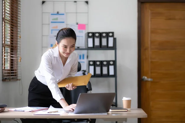 Young woman working on a laptop in the office. Asian businesswoman sitting at her workplace in the office. Beautiful Freelancer Woman working online