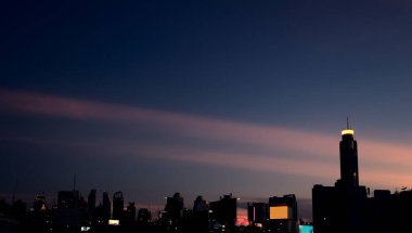 Klasik tarz modern şehir kompleksi binalar gökdelen gökdelenler gün batımında panoramik siyah arka planda. Hava görünümü.