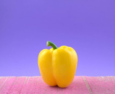 Açık sarı biber renginde, grunge pembe çimento plakalı yeşil çan biberli sebze. Hayat, güzel sanatlar, modern sanat, minimalizm imaj tarzı.