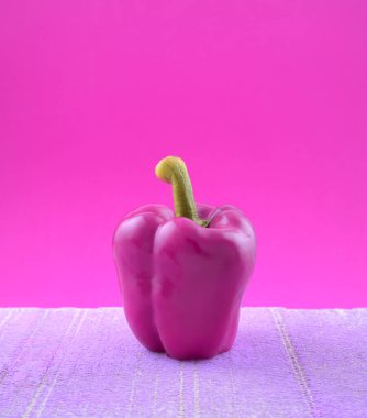 Pastel mor dolmalık biber renginde, grunge çimento üzerinde sebze. Durgun yaşam, güzel sanatlar, organik imaj.