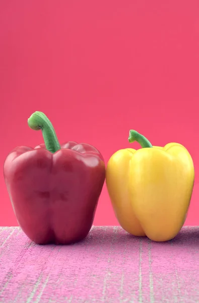 Renkli pastel rengi mor, sarı dolma biber kompozisyonu pembe arkaplana karşı pembe grunge çimento.