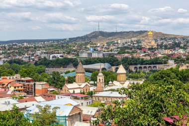Tiflis, Gürcistan, 07.21.2019. Tiflis 'in panoramik manzarası. Eski şehirdeki kilise kubbeleri, başkanlık sarayı ve uzaktaki yerleşim alanları.