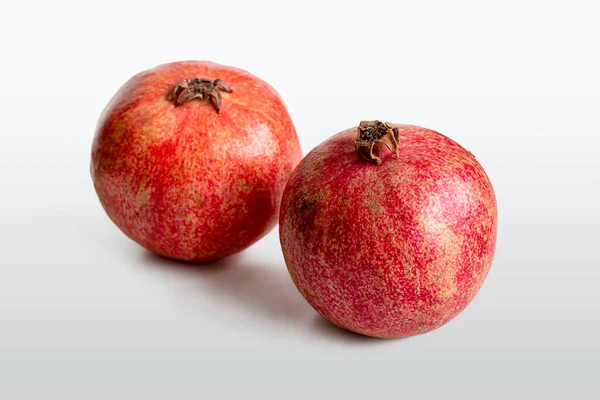 两种成熟的红色石榴 有可食用的多汁谷粒 背景浅 — 图库照片