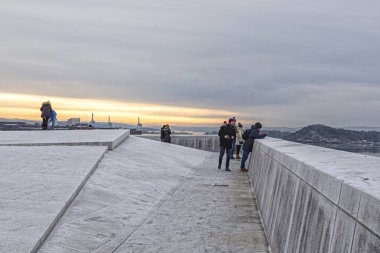 Oslo, Norveç, 12.01.2019. Norveç Ulusal Opera Binası 'nın çatısındaki gözlem güvertesinde, Oslo fiyortunun kıyısındaki turistler.