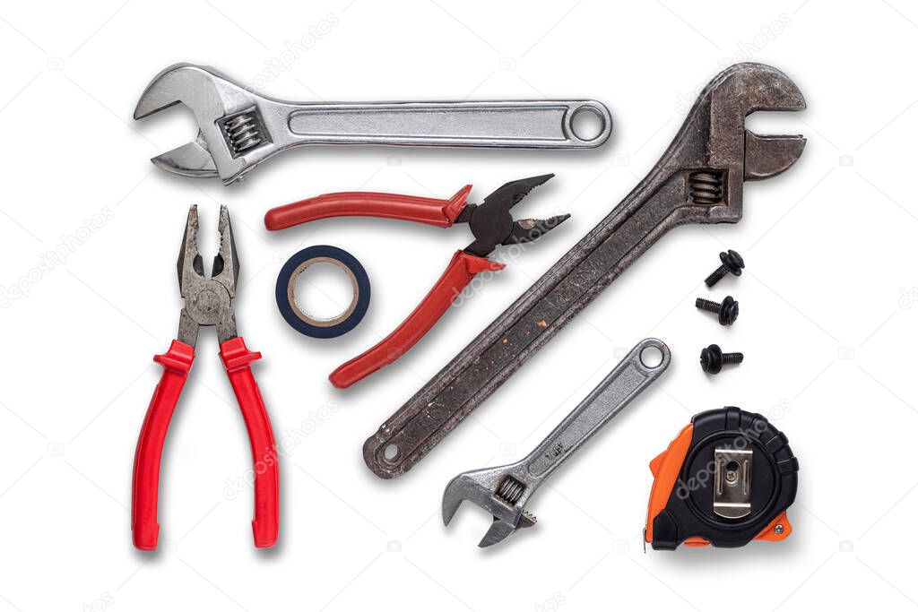Several wrenches, pliers, measuring tape measure, unscrewed bolts and insulating tape on a white background