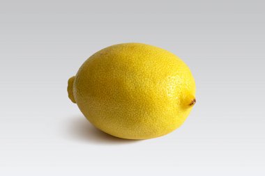 Gözenekli kabuklu sarı limon masanın arka planında uzanır.