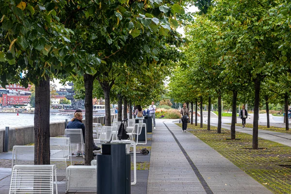 Moskova, Rusya, 09.10.2021. Kırım seti üzerindeki yaya geçidinde düzgün masalar ve sandalyeler, ağaçların arasında yürüyen insanlar.
