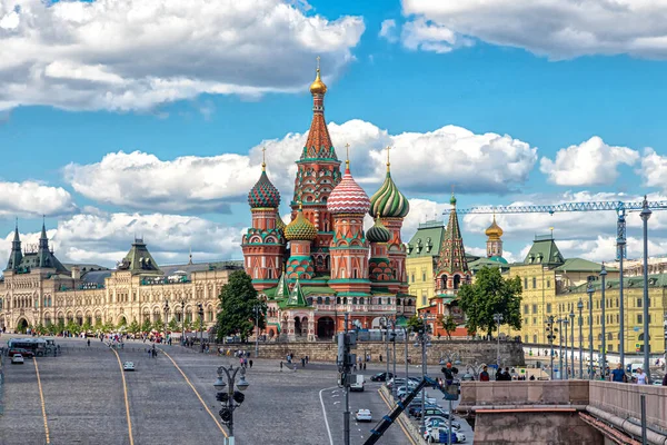 Moskova, Rusya, 05.25.2021. St. Kubbe 'nin manzarası Basil Katedrali, Kızıl Meydan, GUM binası ve Vasilievsky Descent bulutlu mavi gökyüzüne karşı