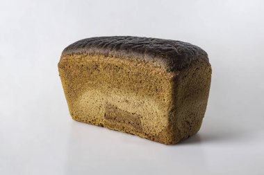 Buğday ve çavdar unundan yapılmış bir somun siyah ekmek, açık arkaplanda koyu kahverengi bir üst kabuk.