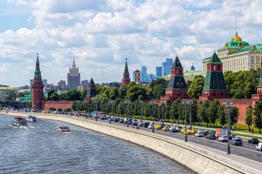 Moskova, Rusya, 06.19.2018. Kremlin Kuleleri manzarası, Moskva Nehri eğlence tekneleri ve güneşli bir yaz gününde arabalarla dolu Kremlin seti. Şehir manzarası