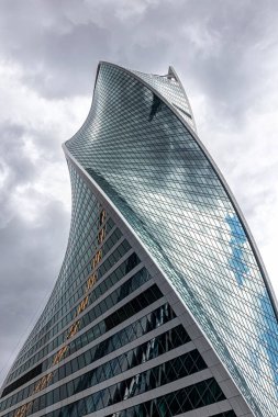 Moskova, Rusya, 07.23.2021. Moskova 'nın iş bölgesinde aynalı pencereli Spiral Kule' Evolution 'fırtınalı gökyüzüne vidalanmıştır.