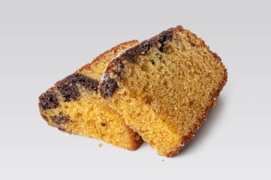 Hafif bir kahvaltı için iki parça altın hamurlu kek arka planda uzanır.