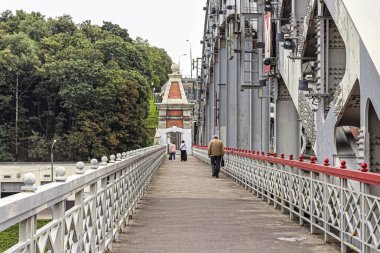 Moskova, Rusya, 09.04.2020. İnsanlar Moskva Nehri 'ni yaya yolundan geçerek Andreevsky Köprüsü' nün metal kemerini geçtiler.