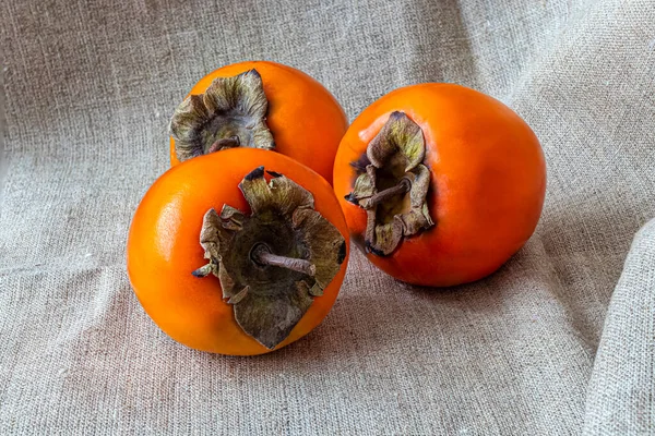 Pochi Frutti Cachi Arancioni Brillanti Maturi Uno Sfondo Tessuto Tela — Foto Stock