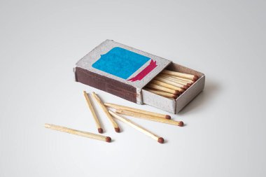 Masanın ışık yüzeyine dağılmış kibritlerle dolu karton kutu