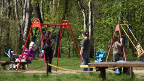 Barn med sina mödrar, svänga i parken — Stockvideo
