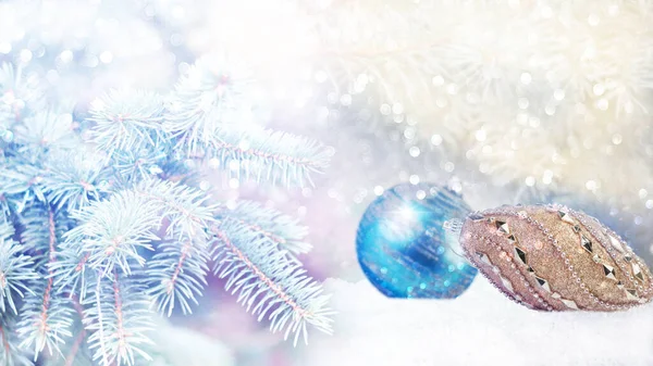 Soyut çözülmüş açık mavi arka planda, köknar dalları ve kar yağışı olan Noel ağacı oyuncakları. Kış mevsimi afişi.