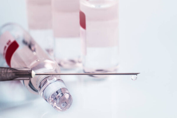 медицинский шприц и лекарства для инъекций на белом фоне