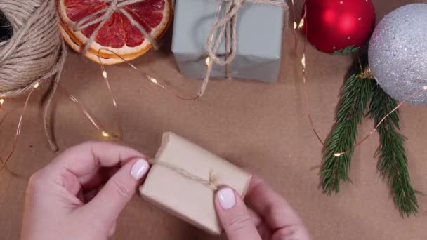Tying bow on gift box packed in craft paper Christmas background — Stock Video