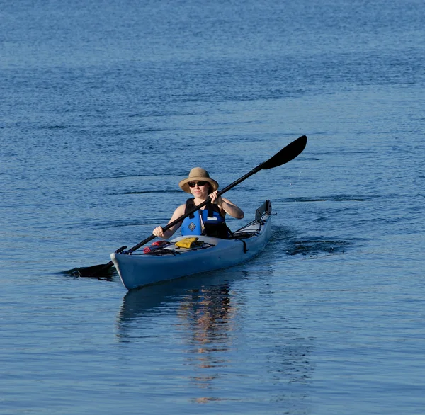 Aantrekkelijke jonge vrouwelijke kayaker roeien — Stockfoto