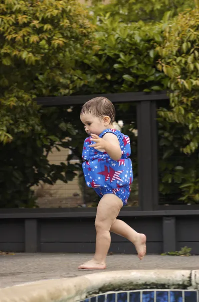 Infant girl running by the pool 3 — Stock Photo, Image