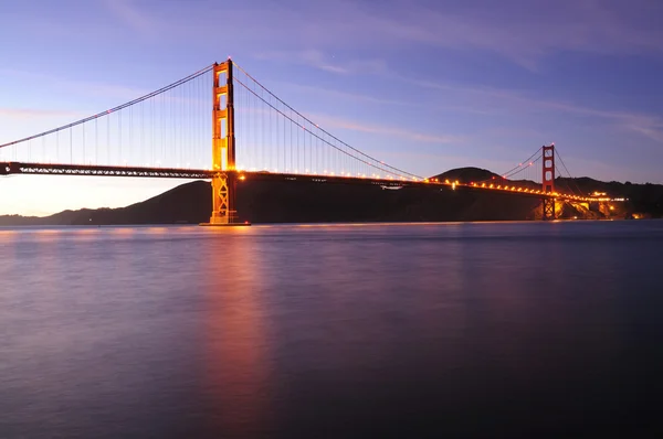 Gloeiende golden gate brug bij zonsondergang Rechtenvrije Stockfoto's