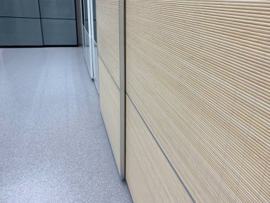 Modern gardırobun sürgülü kapıları, kahverengi ahşap gübre panelleri olan kasa bölmesi bir evin koridorunda..